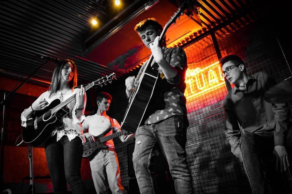 Young rock band having fun playing music on stage.