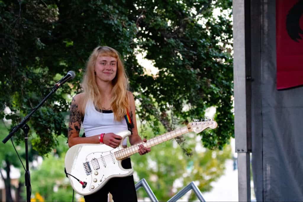 Woman playing guitar outside, having fun and happy.