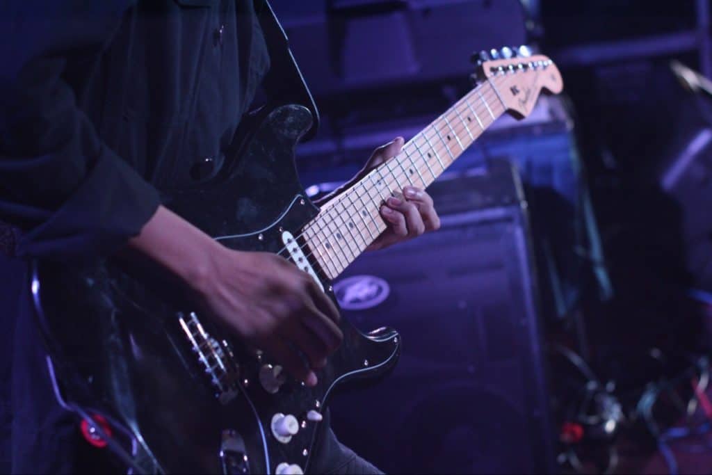 Man in black shirt playing guitar.