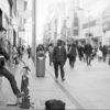 Doing good busking outside, having fun playing guitar. Black and white photo.