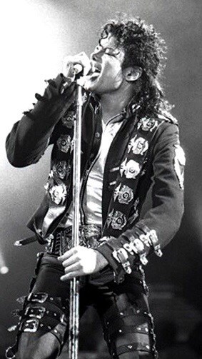 Michael Jackson singing into microphone with great jacket on. Black and white picture. Photo courtesy of Zoran Veselinovic. commons.m.wikimedia.org