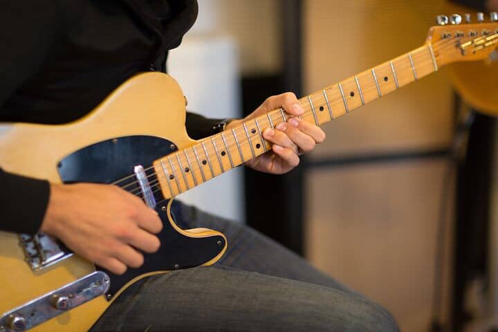 Playing guitar sitting down.