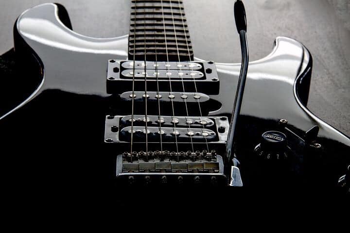 Glossy black guitar laying face up, on table.