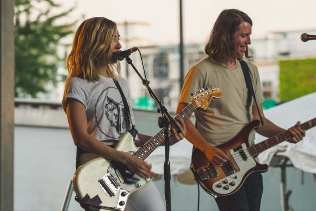 Man and woman playing guitar outside, having fun!