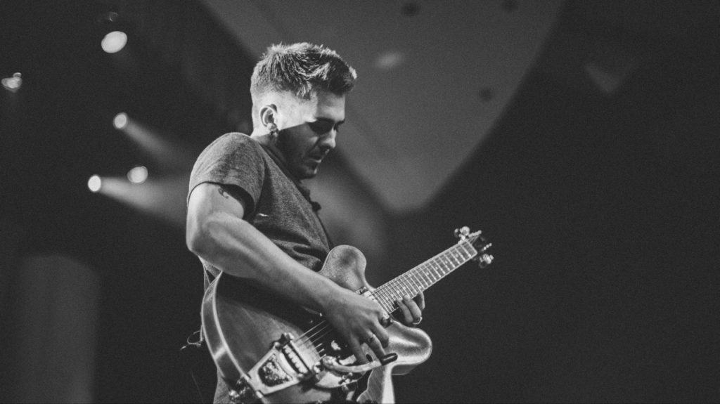 Guitar player, playing up the neck of the guitar. Black and white picture.