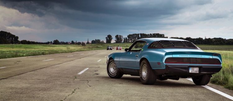 Real fast blue Camero race car on track, with other cars in front of it.