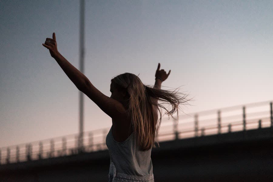 Race girl throwing hands in the air, to declare winner.