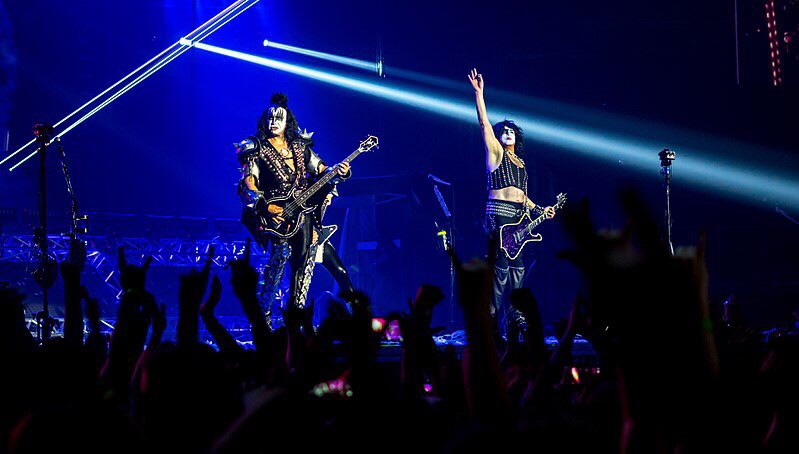 KISS jamming on stage. With Paul Stanley raising one hand.