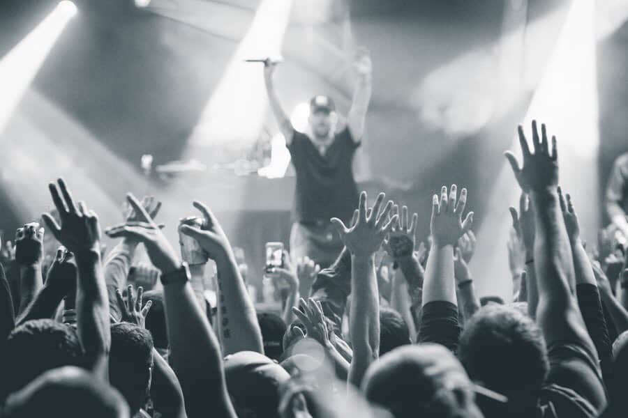 Hip Hop crowd throwing hands up in the air, in music scene.