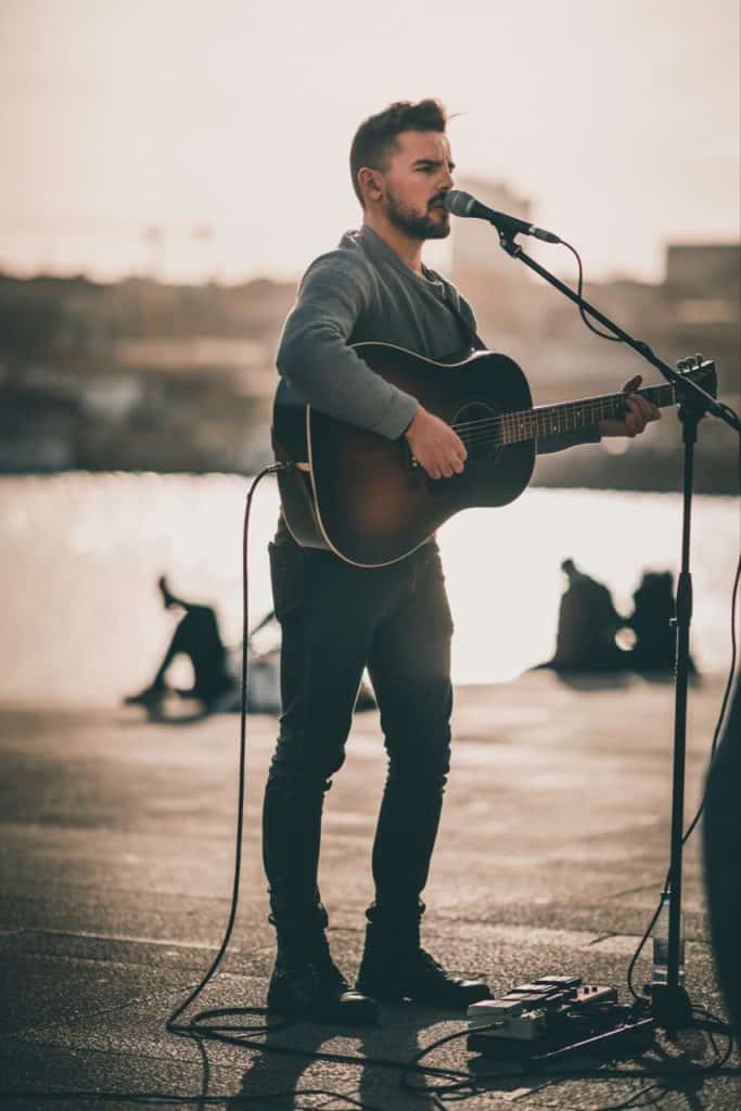 Playing guitar outside, having a great time before people.