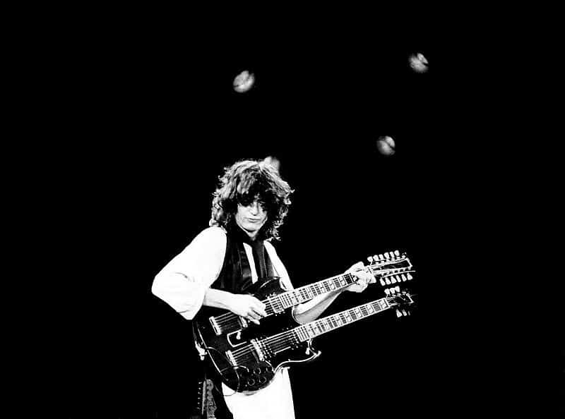 Jimmy Page of Led Zeppelin playing double guitar. Having fun. Black and white picture. Photo courtesy of Andrew Smith commons.m.wikimedia.org