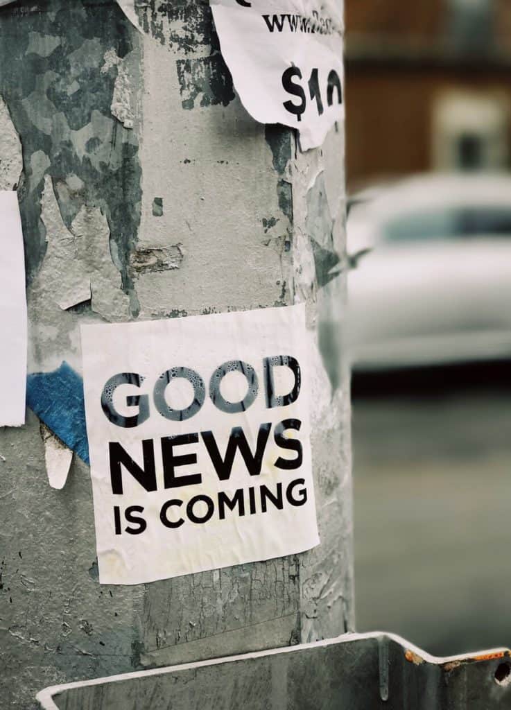 Good news paper sign, hanging on post, outside.