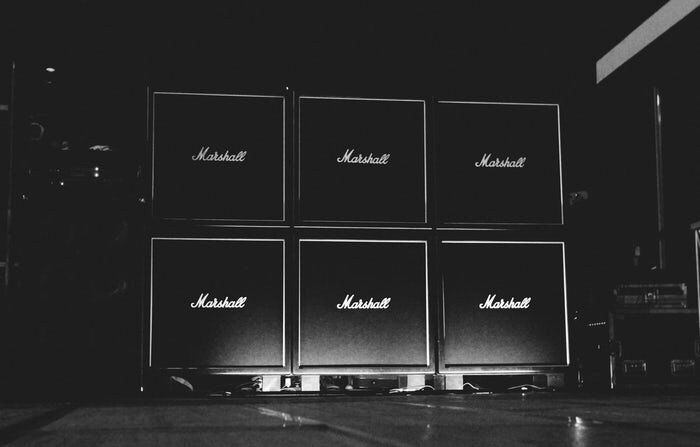 6 huge, black Marshall guitar amps, stacked.