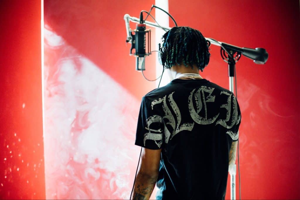 Rich the kid singing into professional microphone, showing his skills. Photo courtesy of Joel Muniz on unsplash.com