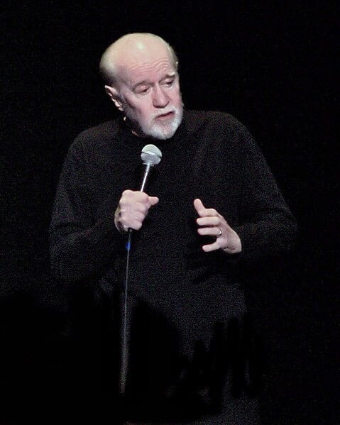 George Carlin File:Jesus is coming.. Look Busy (George Carlin).jpg Carlin performing one of his last shows in 2008. Photo courtesy of Bonnie from Kendall Park, NJ, USA