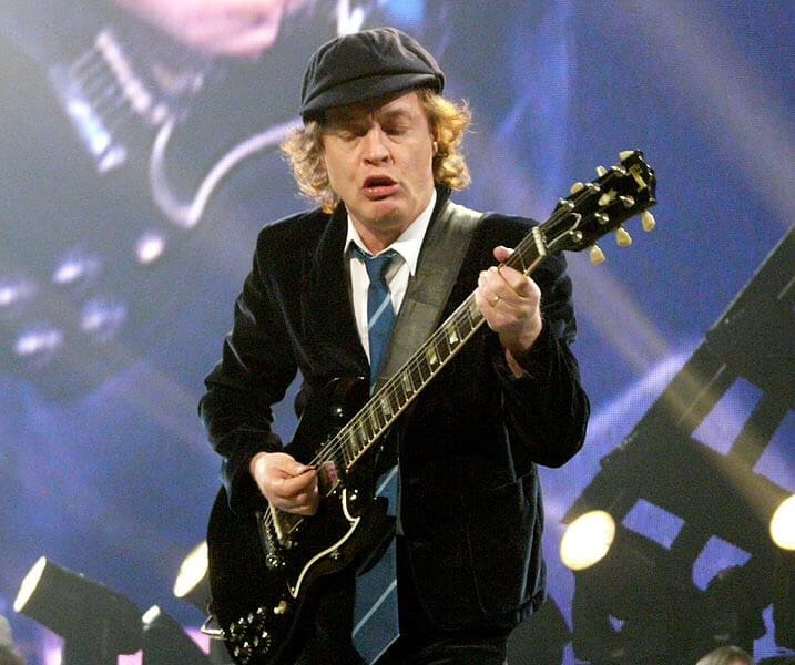 Angus Young Of AC-DC playing hard rock guitar.