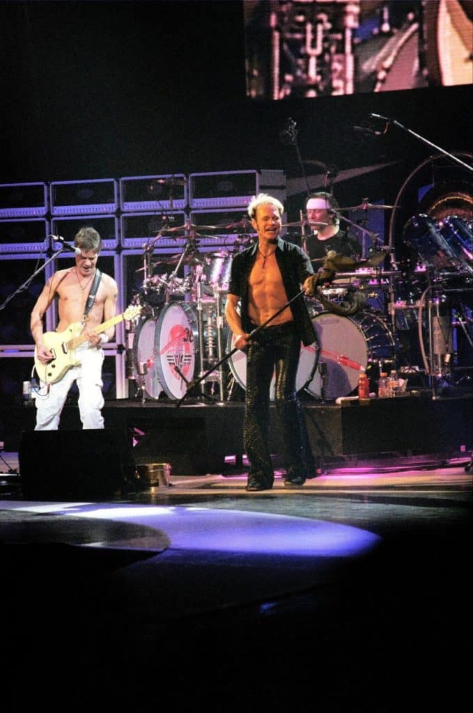 Van Halen (left of photo) playing guitar on stage.