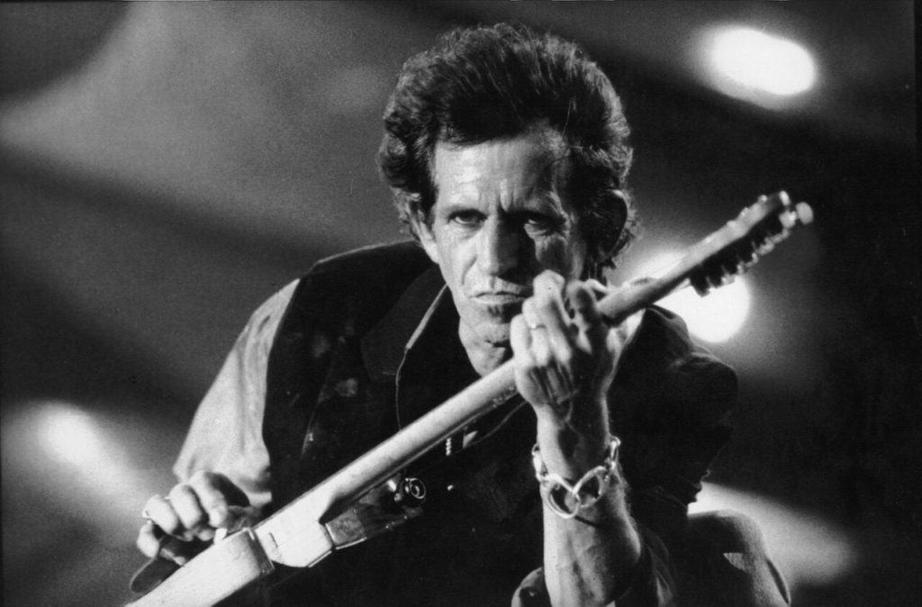 Keith Richards playing massively on his guitar. Black and white picture.