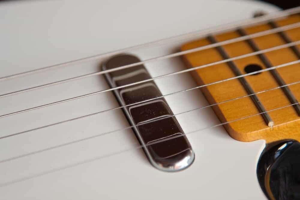 White guitar laying face up.