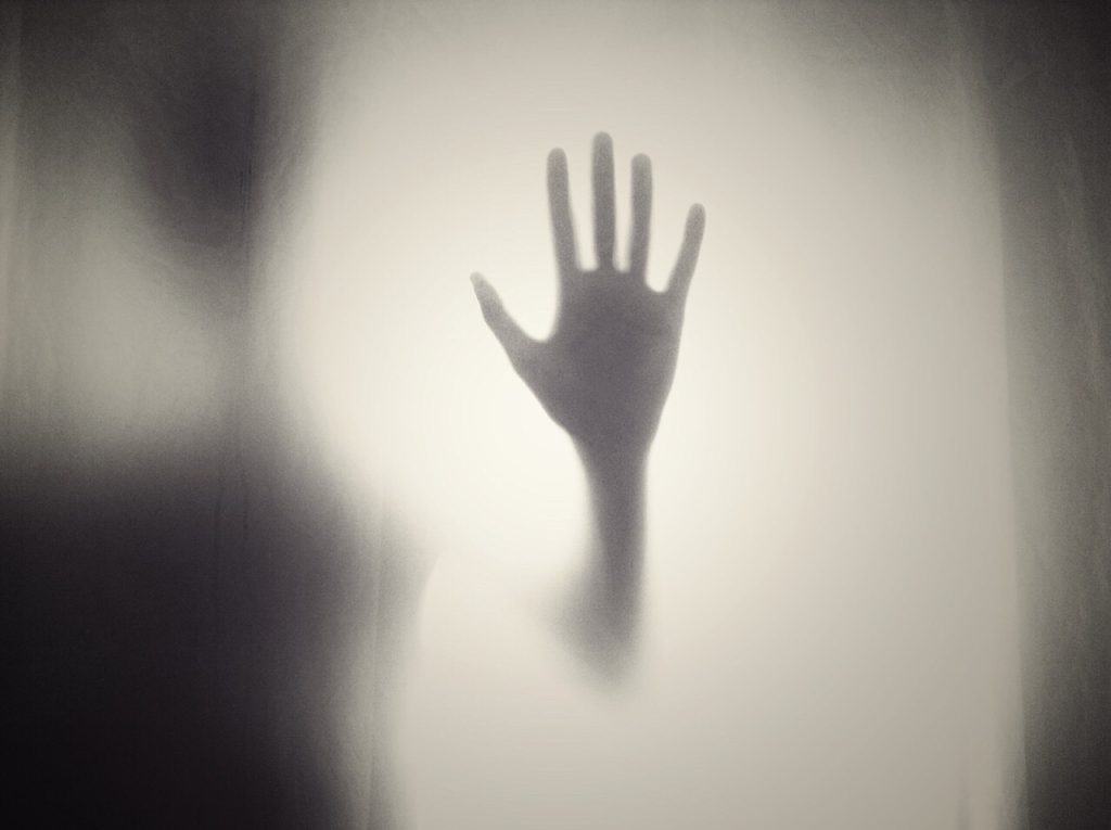 Horror looking hand. With lights shining around it, making it look spooky. Black and white picture.