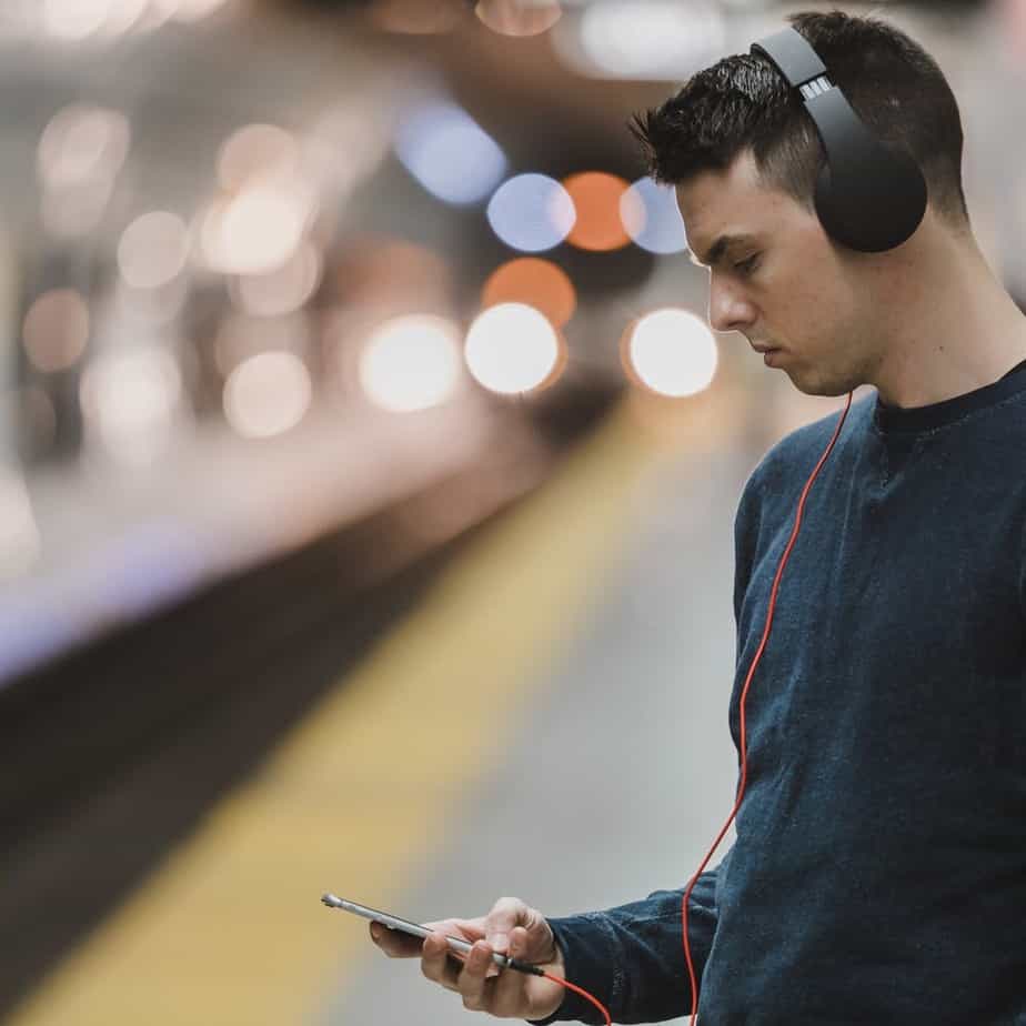 Young man listening to cellphone with headphones on.