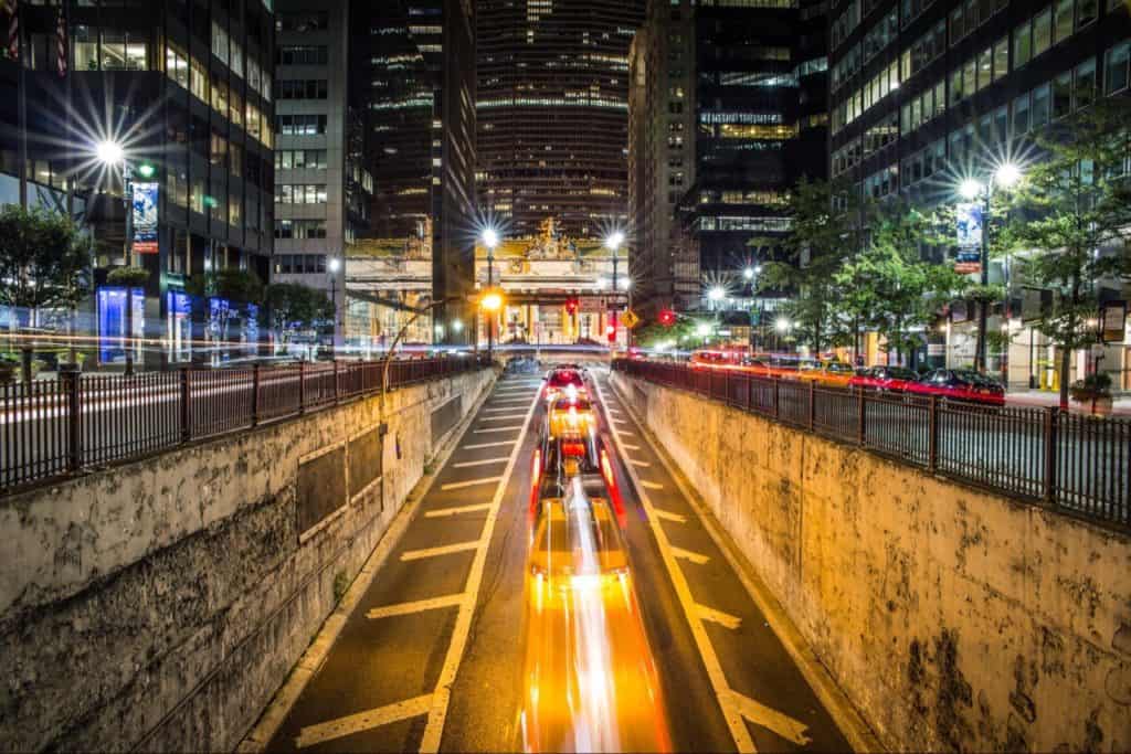 Cars coming out of underpass, surrounded by tall buildings, New York United States. Photo courtesy by Nicolai Berntsen on Unsplash