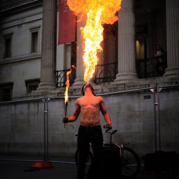 Featured image: Man breathing MASSIVE fire outside his mouth, entertaining people.