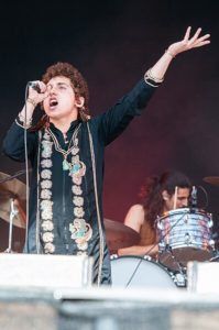 Josh Kiszka singing confidently, with Dan Wagner behind him, playing drums.