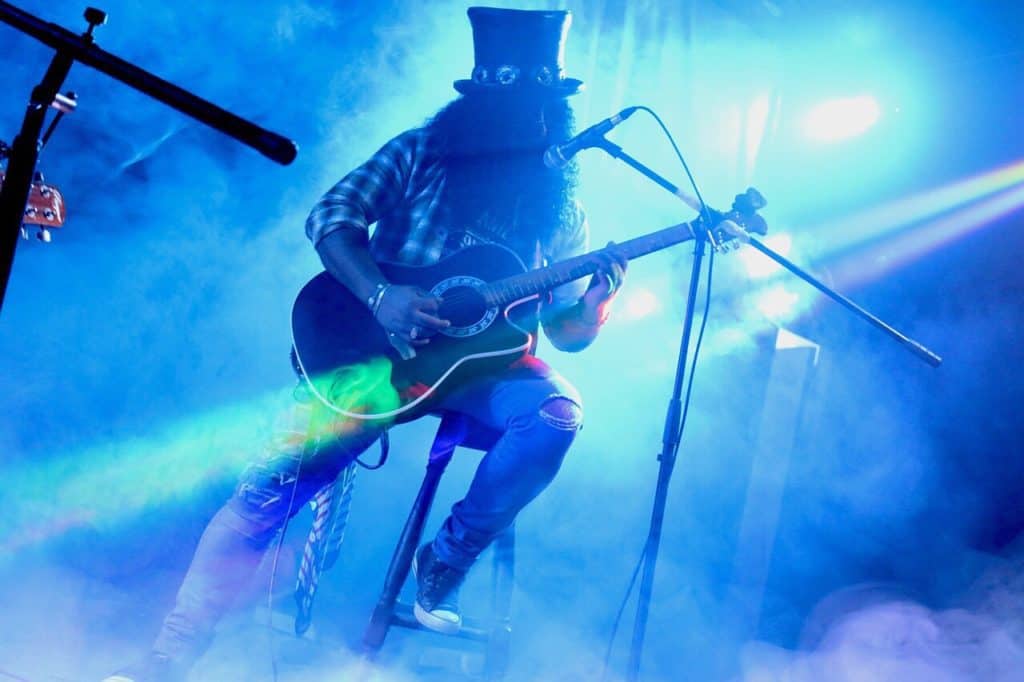 Slash, slashing up the guitar, with blue lights flashing around him, with a kaleidoscope of shining lights, shining all around him.