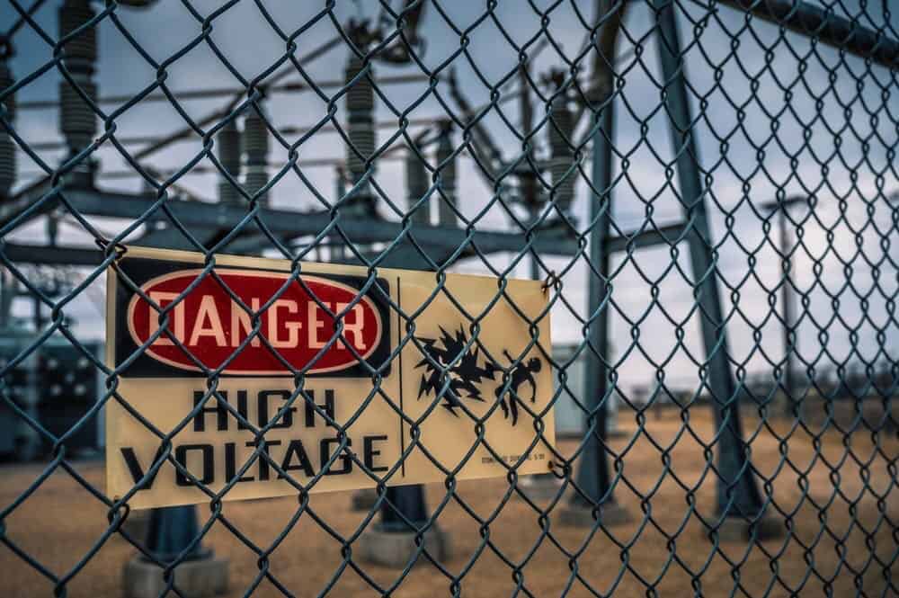 Danger electricity sign and electricity power transformer behind it.