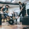 An excited rock band playing their instruments with enthusiasm.