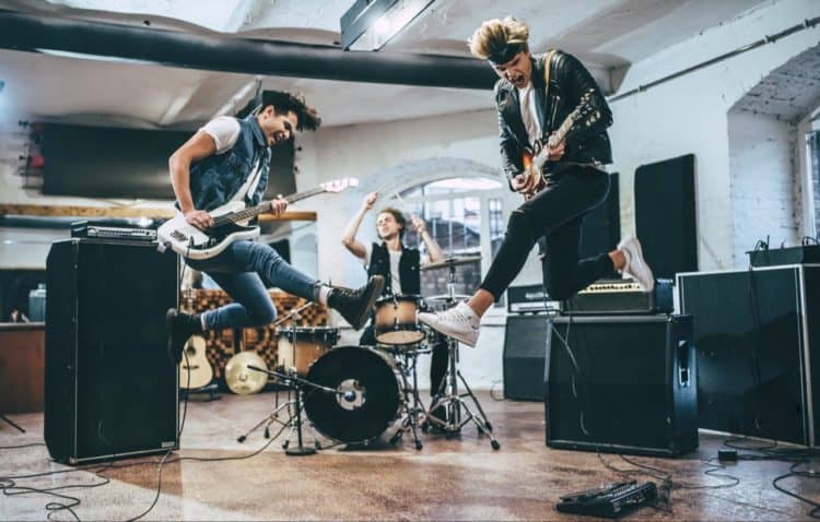 An excited rock band playing their instruments with enthusiasm.