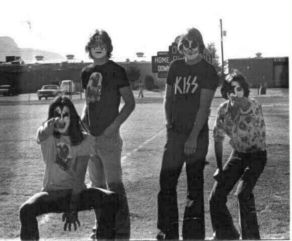 Teens dressed like the famous KISS rockstar musicians, on the teens, high school campus.