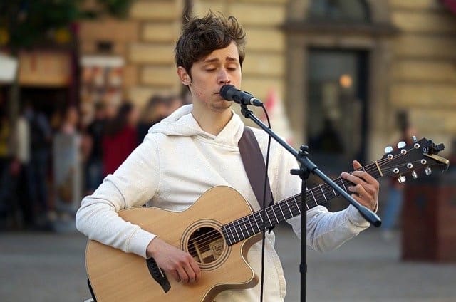 Young man playing the guitar and humming.