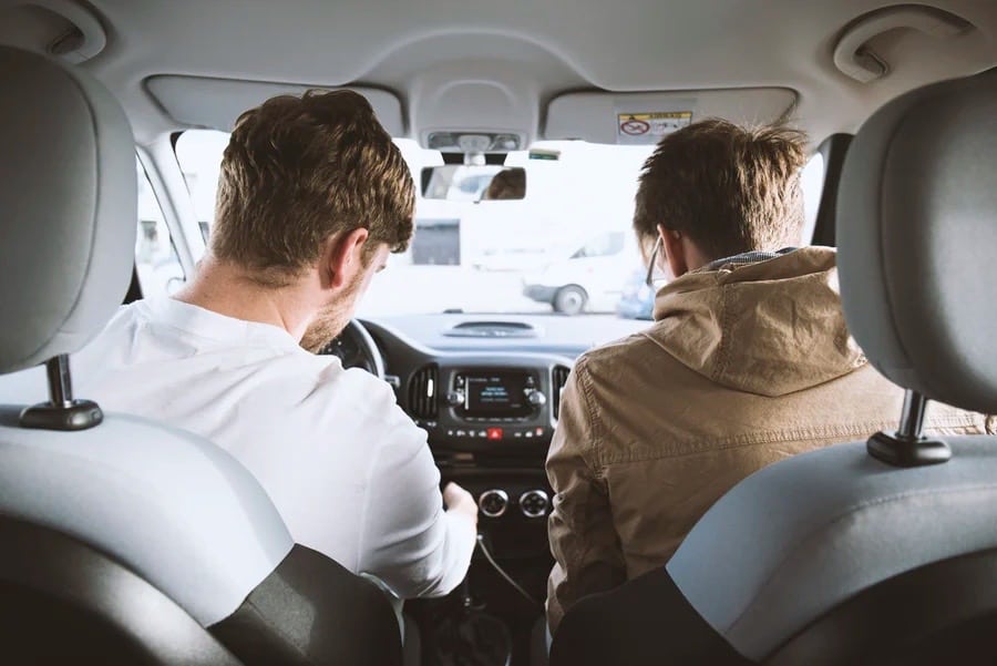 Guys in car, listening to the radio.