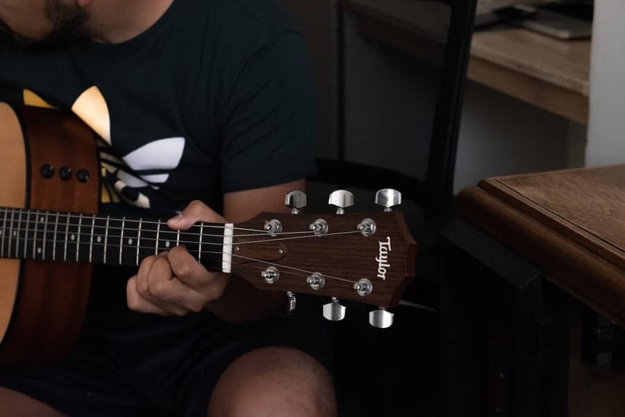 A musician playing a open chord on the guitar.